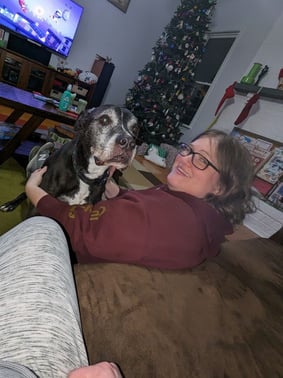 a person sitting on a couch with a dog